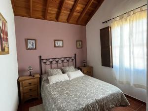 马佐Casa Los Calderos的一间卧室设有一张大床和一个窗户。