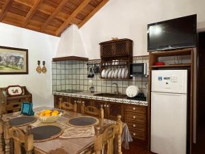 马佐Casa Los Calderos的厨房配有桌子和白色冰箱。