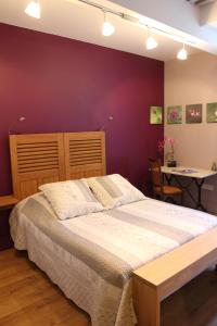 La Côte-Saint-AndréLa tour Bocsozel的一间卧室设有一张大床和紫色的墙壁