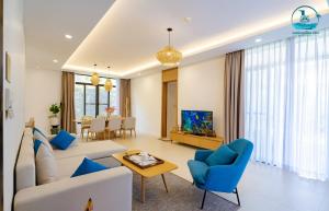 金兰Lumina Villas Cam Ranh, Bai Dai beach luxury resort villas的客厅配有白色沙发和蓝色椅子