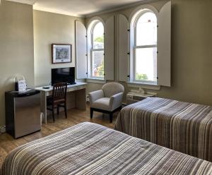 卢嫩堡卢嫩堡埃马姆酒店的酒店客房 - 带两张床、一张桌子和一把椅子