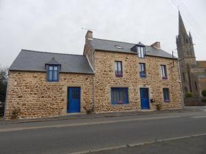 Saint-DenoualAu Ker Lauriers chambres et table d Hôtes的街上有蓝色门的砖砌建筑