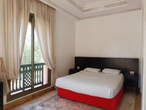 马拉喀什palmeraie village 2的一间卧室设有一张床和一个大窗户
