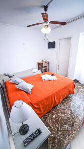 内科切阿Hotel Parque的一间卧室配有橙色的床和一张带台灯的书桌