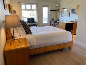 托菲诺弗雷德狄博思岛村酒店的一间卧室配有一张床和一张带台灯的桌子