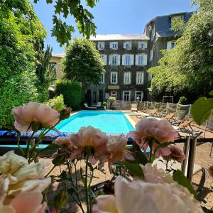拉科纳乐霍勒迪弗杰斯酒店的一座建筑物前的游泳池,里面装有粉红色的花朵