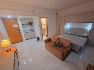 马瑙斯Tropical Executive Vista Ponta Negra的一间大卧室,配有一张床和一张沙发