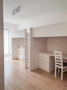 克拉科夫Apartment Szwed-Sniadowskiej Residence的一间卧室配有书桌和一张带两把椅子的床。