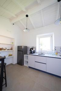 泰拉奇纳NUMISIA Guest House的厨房配有白色橱柜和黑色冰箱。