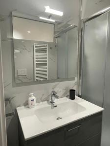 切萨雷奥港Aura Apartments - Orizzonte Turismo的一间带水槽和镜子的浴室