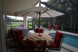 基西米艾利特公寓酒店 - 坎伯兰湖区的游泳池旁配有遮阳伞的桌椅