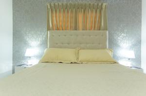 圣斐利-银港MB Apartment - A的卧室配有带两盏灯的白色床