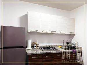 瓜达拉哈拉Departamento Loma-Alta的厨房配有白色橱柜和不锈钢冰箱