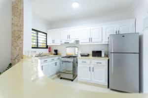 圣斐利-银港MB Apartment - A的厨房配有白色橱柜和不锈钢冰箱