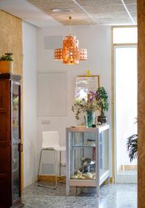 桑蒂蓬塞Italica Hostel的一间设有桌子、鱼缸和吊灯的房间