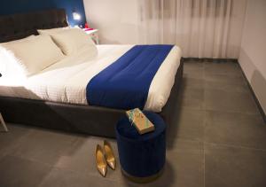 那不勒斯NAPOLI IN BLU MAISON的酒店客房,配有一张带桌子和鞋子的床