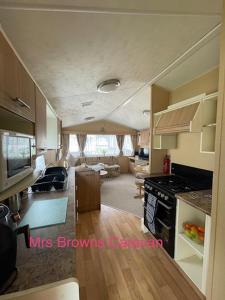 Little Clacton6 Berth, pet friendly caravan with decking的厨房以及带炉灶烤箱的客厅。