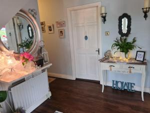塔拉莫尔Coreen Guest House的一间设有镜子、梳妆台和门的房间