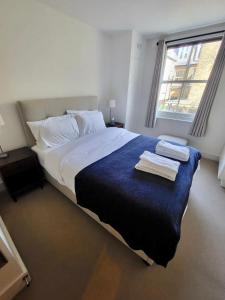 伦敦Lovely newly refurbished apartment in Battersea的一间卧室配有一张大床和毛巾