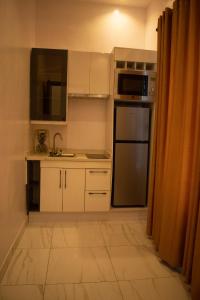 伊凯贾Sapphire Residences by Crystal的厨房配有白色橱柜和不锈钢冰箱