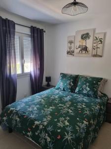 阿维尼翁maison cosy avec petit jardin的一间卧室配有一张带绿色棉被的床