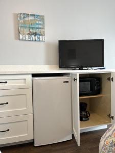 新士麦那海滩Coastal Life 206 - A 2nd Floor Studio With 2 Single Beds的一张带电视和白色冰箱的白色书桌