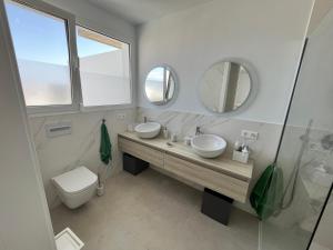 科斯塔特吉塞Casa el Timple的浴室设有2个水槽、卫生间和镜子。