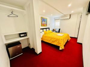 阿里卡Le Prince Arica的一间卧室配有黄色的床和红色地毯