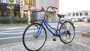 贝冢市Sunrise Inn - Vacation STAY 75396v的停在街边人行道上的一辆蓝色自行车