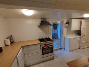 阿伦达尔Sørlandshus med 3 soverom的厨房配有白色橱柜和炉灶烤箱。