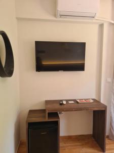 克里皮吉Este Luxury Apartments的一间房间,墙上设有一张桌子和一台电视