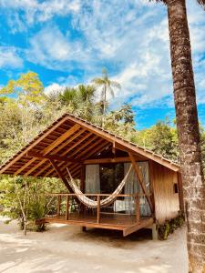 ManacapuruCirandeira Amazon World EcoResort的海滩上带吊床的房子