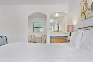 卡利斯托加Carlin's Cottage Court的卧室配有白色的床和桌椅