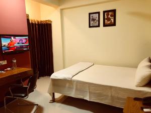 ComillaQ Palace的酒店客房,配有床和电视