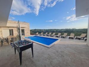 乌马格Villa Mare e Monti with heated pool的庭院中设有1个带椅子和乒乓球桌的游泳池