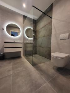 乌马格Villa Mare e Monti with heated pool的一间带卫生间和两面镜子的浴室