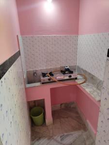 普里Sushamalay Guest House At Sea Beach, Puri的一间粉红色的房间,架子上放着收音机