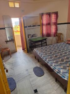 普里Sushamalay Guest House At Sea Beach, Puri的一间卧室配有一张床和一张绿桌