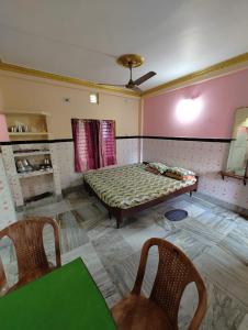 普里Sushamalay Guest House At Sea Beach, Puri的一间设有床铺和两把椅子的房间