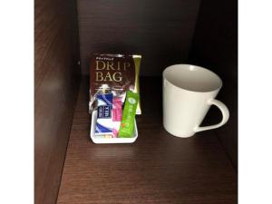 白山市New Matto Terminal Hotel - Vacation STAY 01873v的一杯咖啡和一袋糖,紧挨着杯子