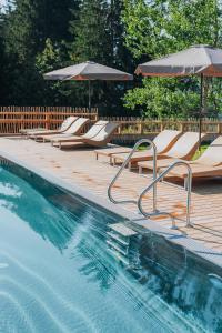 罗伊特Wellness Aparthotel "Lechlife" incl Infinity Pool - 400m zum Lift的一个带躺椅和遮阳伞的游泳池