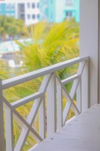 克拉伦代克Caribbean Lofts Bonaire的棕榈树阳台的白色栏杆