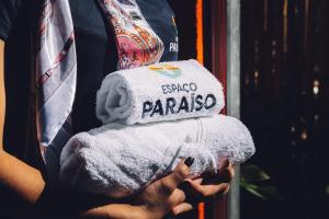 OrtigueiraEspaço Paraíso Ortigueira的手持折叠毛巾的人