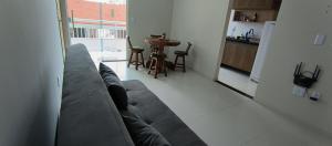巴雷里尼亚斯Confort Lencois Preguicas的一间带灰色沙发的客厅和一间厨房