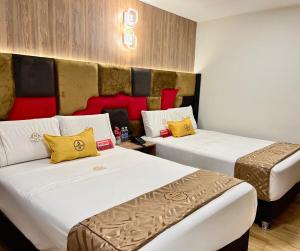 利马Montreal Magdalena Del Mar Hotel的酒店客房带两张带黄色和红色枕头的床
