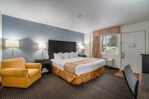 特拉弗斯城特拉弗斯城旅游宾馆的配有一张床和一把椅子的酒店客房