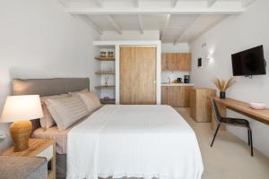 派莱卡斯Casa Sabbia 10m from the beach的一间卧室配有一张床、一张沙发和一张桌子