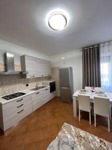 梅斯特Casa di sara的厨房配有白色橱柜和桌椅
