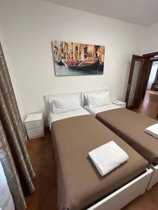 梅斯特Casa di sara的一间卧室设有两张床,墙上挂着一幅画