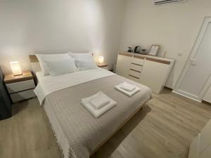 奥赫里德Guest House Stojanoski的一间卧室配有一张大床和两条毛巾